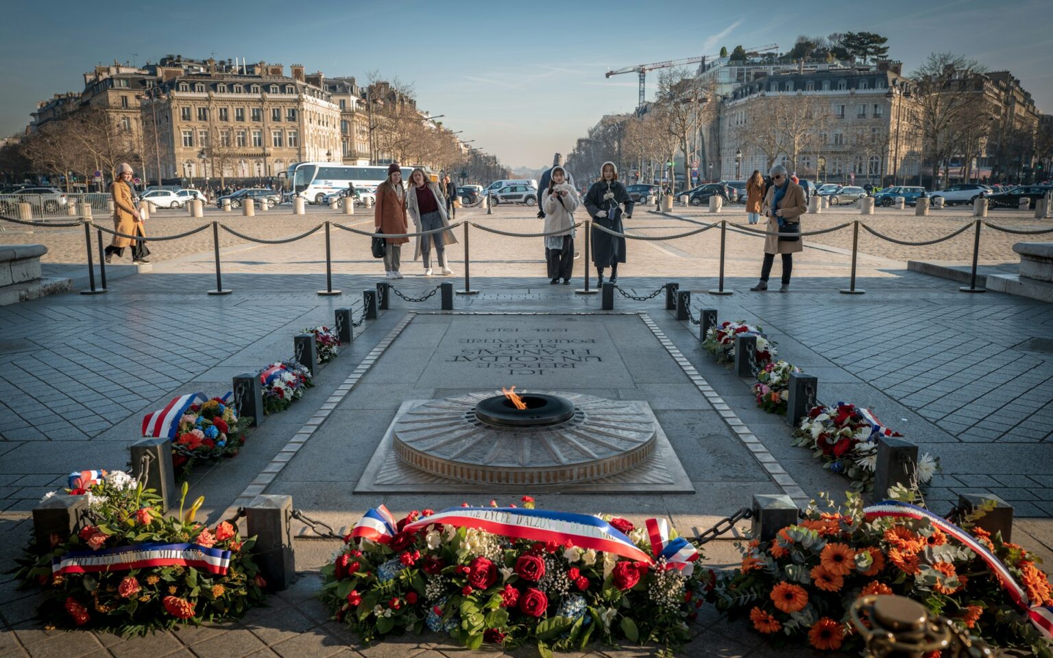 Gerbes de fleurs déposées devant un monument aux morts
