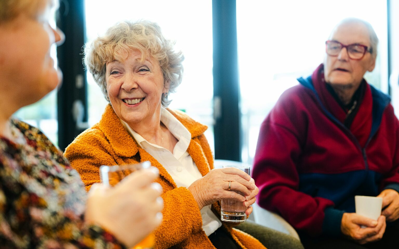 Trois personnes âgées discutent en souriant